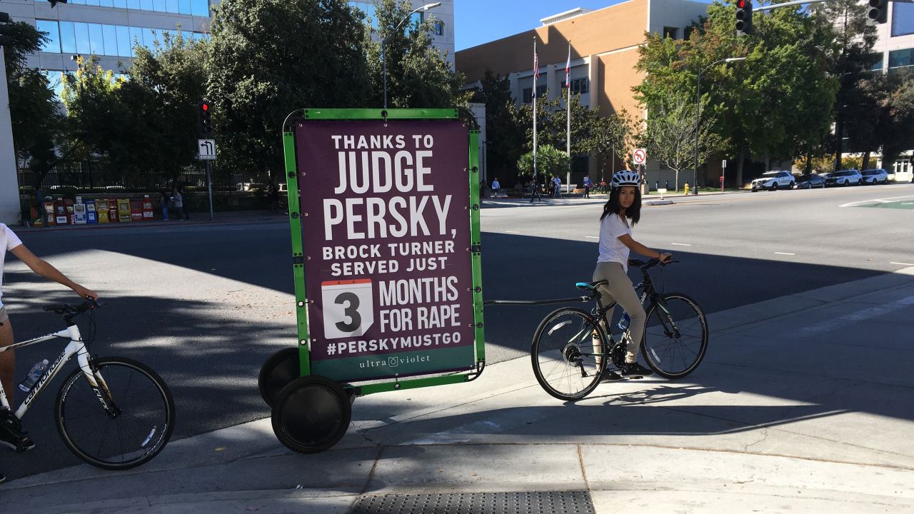 A bicyclist carries a sign critical of the judge's sentencing in the Brock Turner case Friday in San Jose.