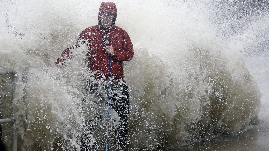 A news reporter works near a sea wall in Cedar Key, Florida, as Hermine neared the coast on Thursday, September 1.