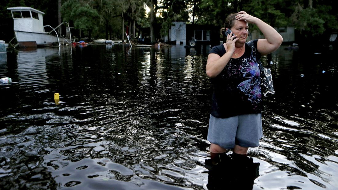 Lynne Garrett speaks to loved ones as she surveys damage outside of her home in St. Marks, Florida, on Friday, September 2. 