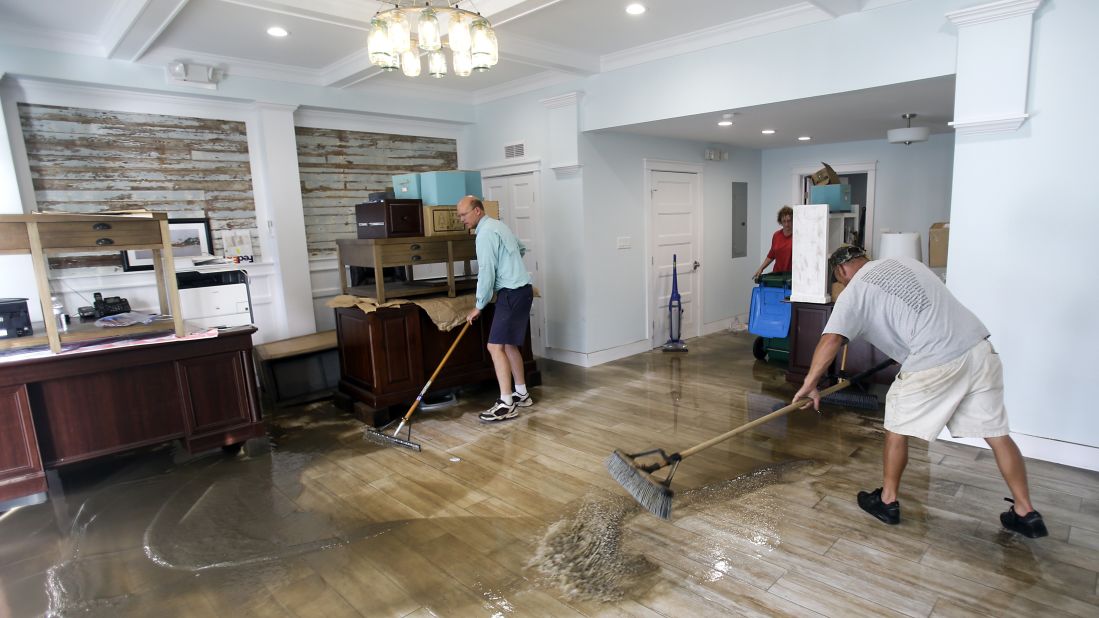 Shawn Stephenson and Marshall Dimick clear water from a real estate office that was flooded by Hermine in Cedar Key, Florida.