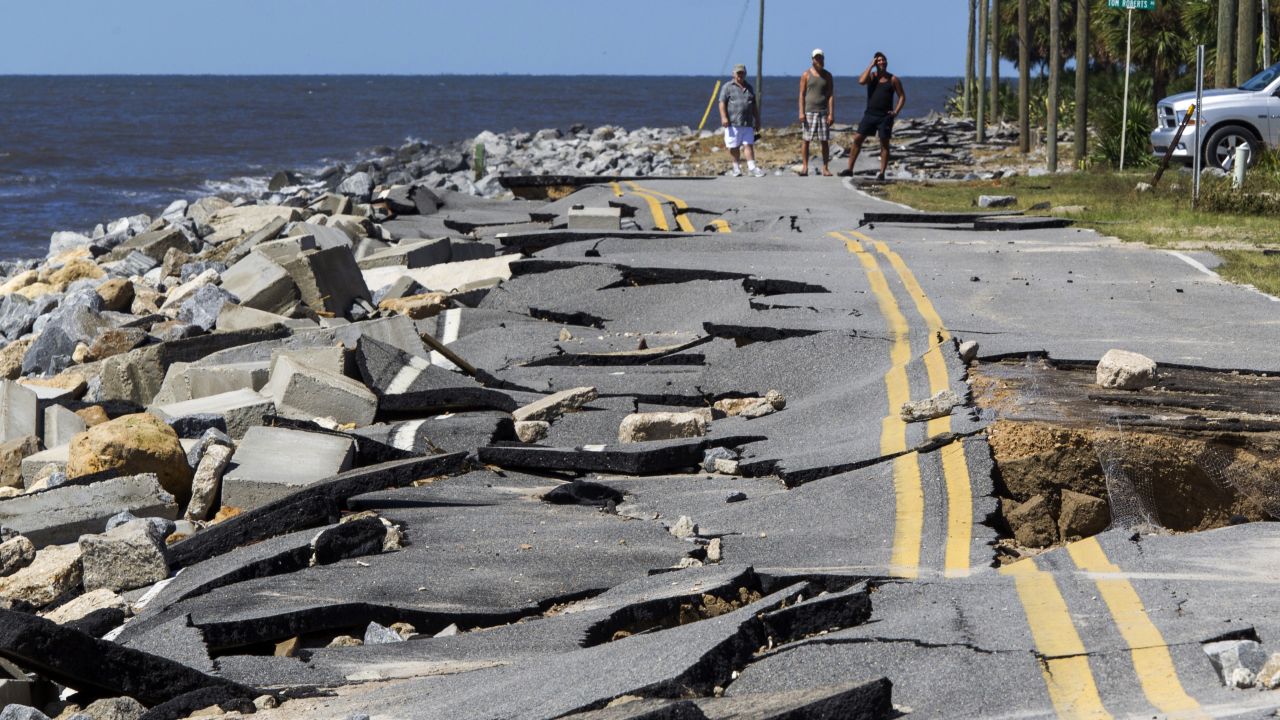 Residents look at an Alligator Point road that collapsed during Hermine's storm surge.