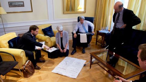 Kerry talks with his staff in 2015 in Paris.