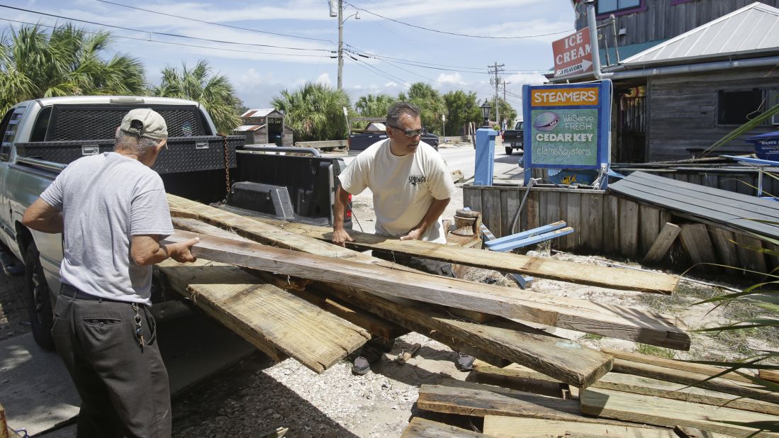 Gus Soldatos and his father, Nick, unload lumber to make repairs on their building September 3, after Hurricane Hermine passed through Cedar Key, Florida.