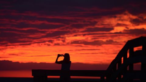 Karen Duer-Potts uses her cellphone to take a photograph of the sunset as the outer band of Hermine creeps over the beach at Cape Charles, Virginia, on September 2. 