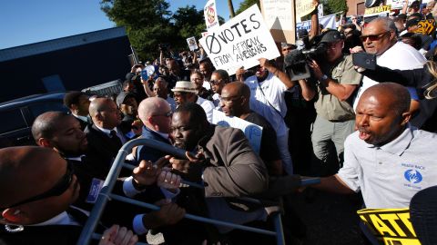 Protesters try to enter the property of Great Faith Ministries Church in Detroit before a visit by Donald Trump on September 3 in Detroit, Michigan.