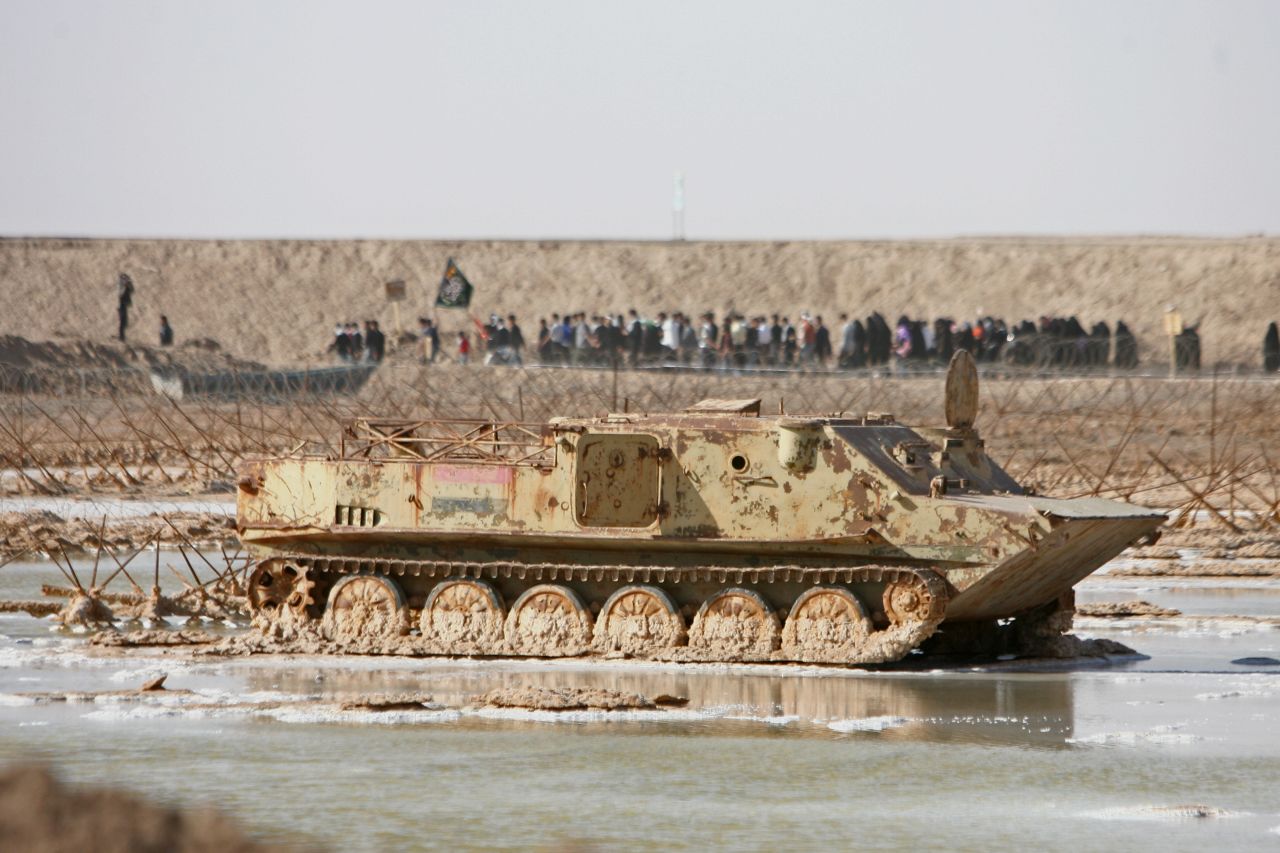 An estimated one million people lost their lives during the war between Iran and Iraq. In this photo taken on the Iran-Iraq border in 2007, Iranians walk past a destroyed tank on their way to pay respects at a memorial site. 