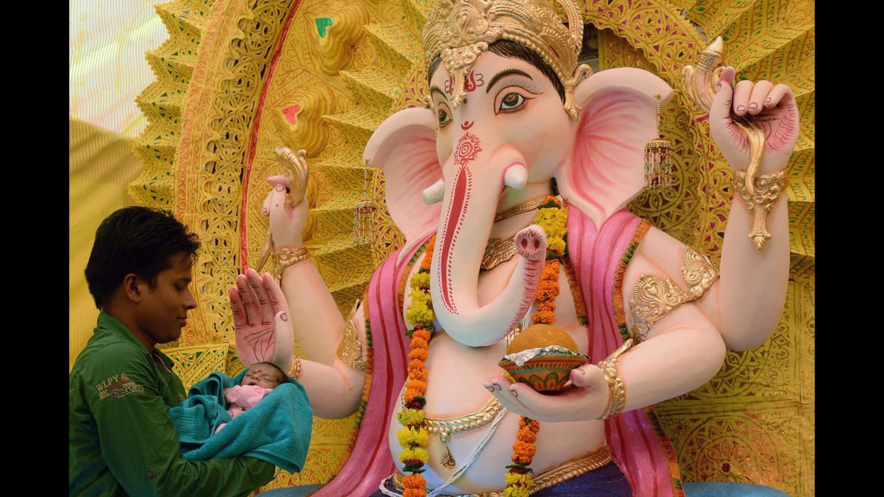 A devotee holds his infant son before a statue of the Hindu god Ganesha during the Ganesh Chaturthi festival in Amritsar, India, on September 5.