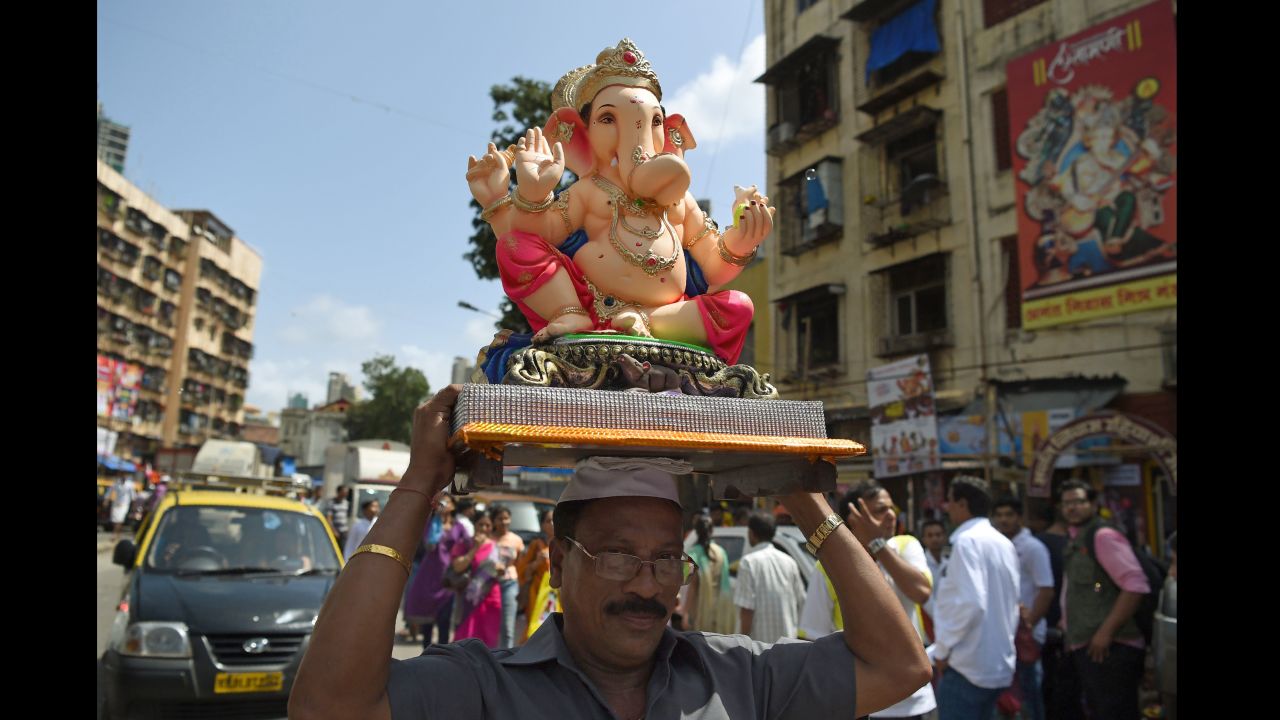 A Hindu devotee transports an elephant idol through the streets of Mumbai, India, on the first day of the festival, September 5. Hindu devotees bring home idols of Lord Ganesh in order to invoke his blessings for wisdom and prosperity.