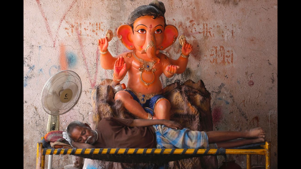 A merchant naps while he waits for customers to buy his idol in Ahmadabad, India, on September 5.