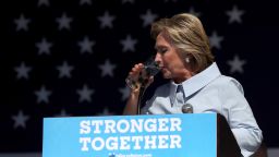 Democratic presidential nominee former Secretary of State Hillary Clinton pauses to take a drink of water to help soothe a cough during a campaign rally at Luke Easter Park on September 5, 2016 in Cleveland, Ohio.