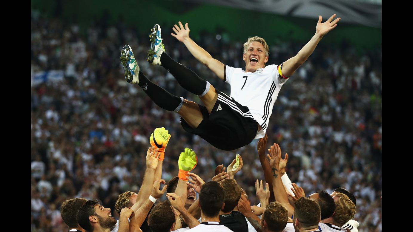 German soccer player Bastian Schweinsteiger is lifted by teammates after playing his last international match against Finland on Wednesday, August 31.
