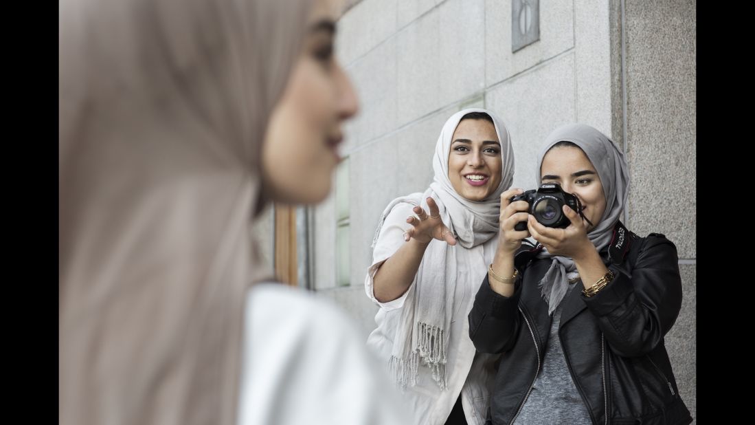 Friends and fashion enthusiasts Imane Asry, Shama Vafaipour and Maryam Dinar take photographs.