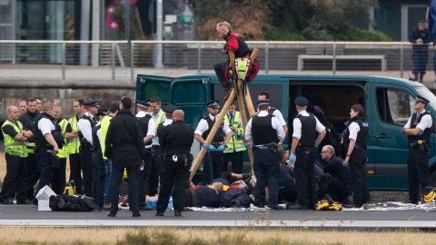 Emergency services surround Black Lives Matter protesters Tuesday on a London City Airport runway.
