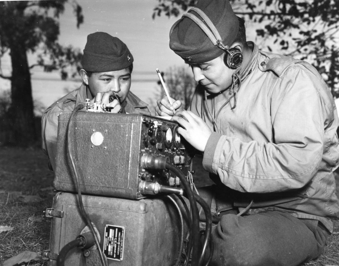 Private First Class Preston Toledo and his cousin, Private First Class Frank Toledo, both Navajos, relay orders over a field radio in their native tongue on July 7, 1943.