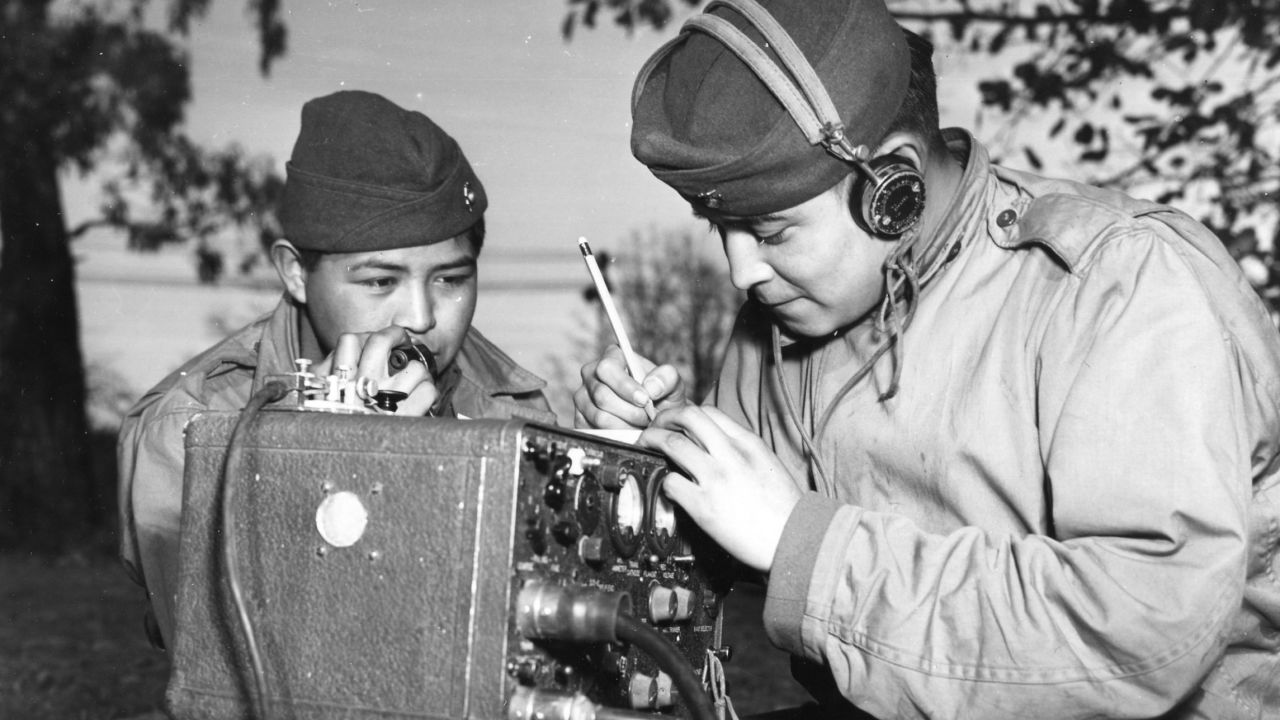 Private First Class Preston Toledo and Private First Class Frank Toledo, cousins and full-blood Navajo Indians, relay orders over a field radio in their native tongue, Ballarat, July 7, 1943.