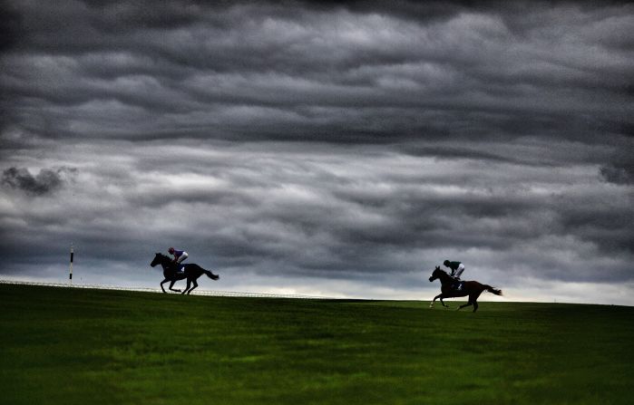 Runners make their way across the center of the track for the start of another Curragh race.