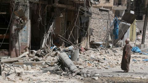 A resident of the Tariq al-Bab neighbourhood of Aleppo looks at damage caused by reported air raids.