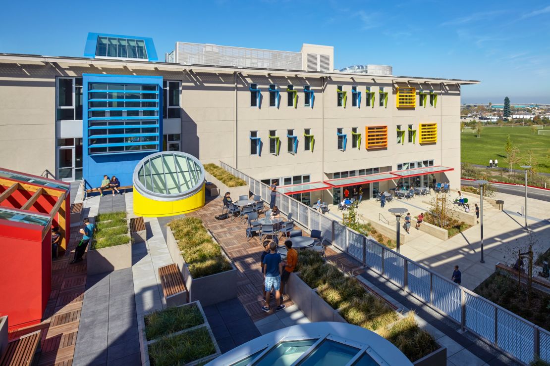 The private Nueva School at Bay Meadows, California in the USA uses existing public resources -- like community playing fields and libraries -- and makes their own spaces available for public use in return. 
