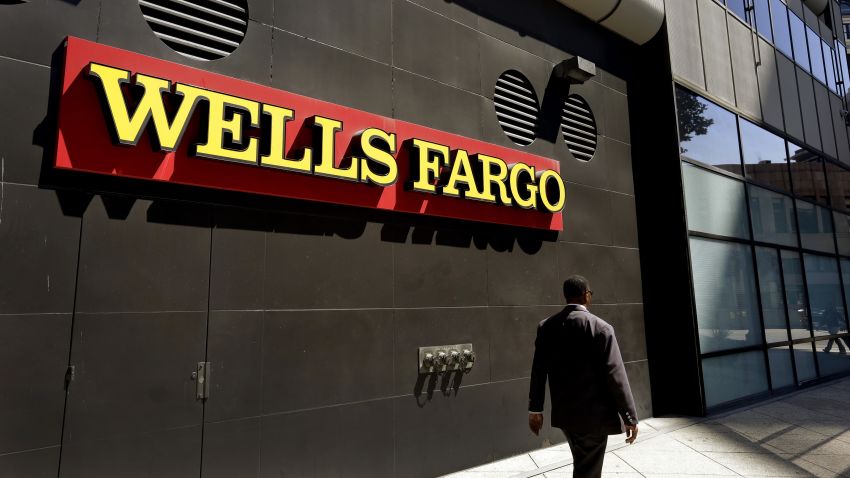 A man passes by a Wells Fargo bank office in Oakland, California. Regulators announced Thursday, September 8 that Wells Fargo is being fined $185 million for illegally opening millions of unauthorized accounts for their customers in order to meet aggressive sales goals.
