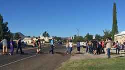 People cross a street in western Texas as Alpine High School is evacuated following a shooting there Thursday, September 8. One person shot and wounded another before the shooter died of a self-inflicted gunshot, Brewster County Sheriff Ronny Dodson said. (Courtesy Alpine Avalanche)