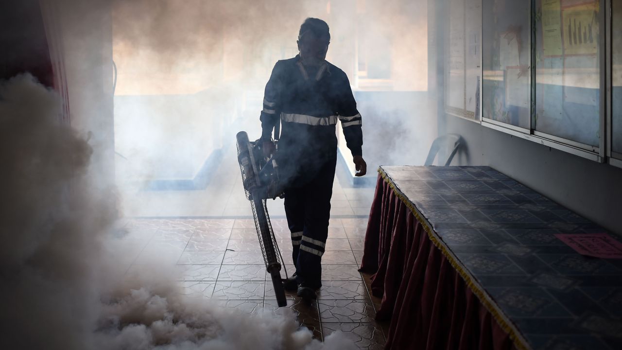 A pest control worker fumigates a classroom in Kuala Lumpur, Malaysia, on Sunday, September 4.