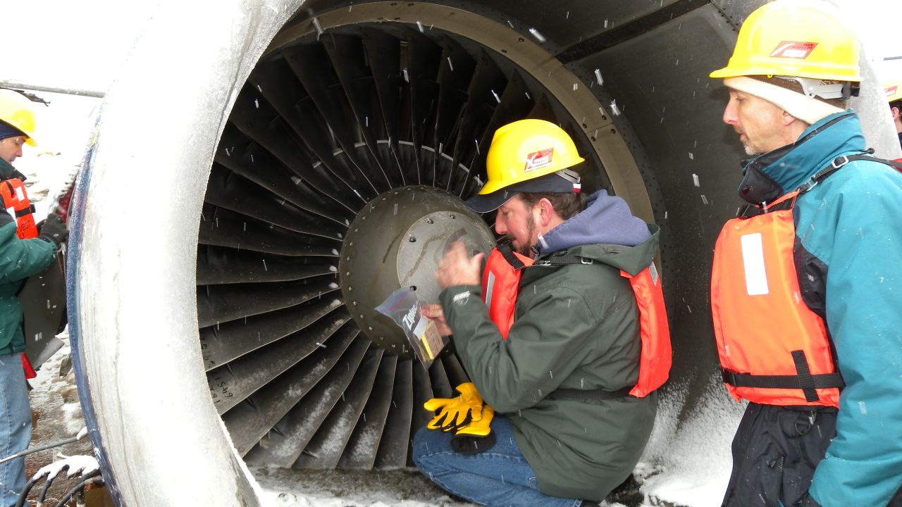 Mike Begier (left) of the USDA  investigates a damaged engine of US Airways Flight 1549 in 2009.