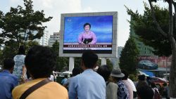 Residents look up at a big screen TV in front of Pyongyang railway station showing television presenter Ri Chun-Hee announcing that the country successfully tested a nuclear warhead earlier in the day on September 9, 2016.