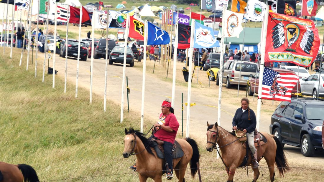 Flags of Native American tribes from across the United States and Canada line the entrance to a protest encampment on Saturday, September 3. 