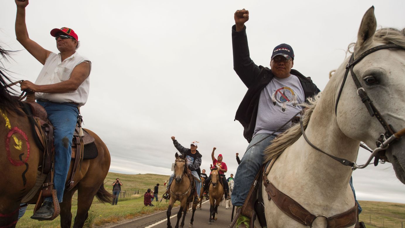 Native Americans ride with raised fists to the sacred burial ground on September 4 to protest the Dakota Access Pipeline.