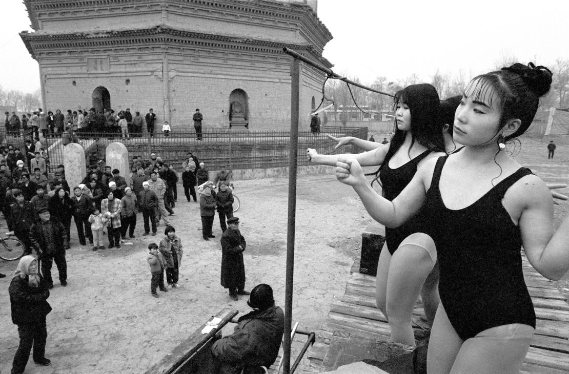 To attract visitors, girls dance in front of Chongwen Tower in China's Shaanxi province. This social documentary photo by artist Peng Xiangjie was part of a series on circus performers in the country.