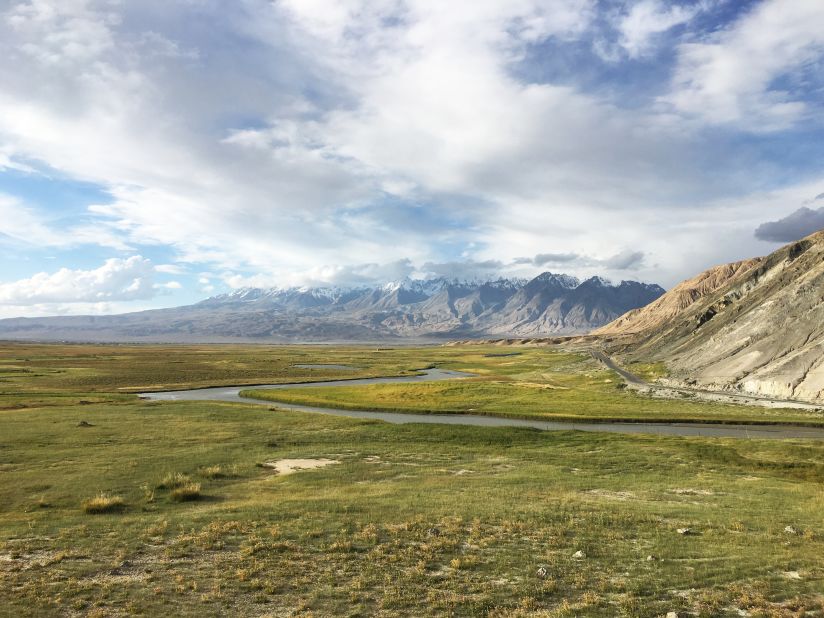 Stunning grasslands appear along the Karakoram Highway, with the Tian Shan range behind.