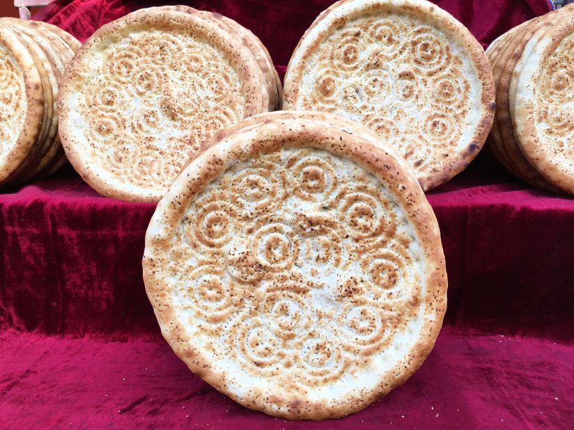 Circular Xinjiang flatbread is sold at the side of the road. It's flavored with onion and sesame.