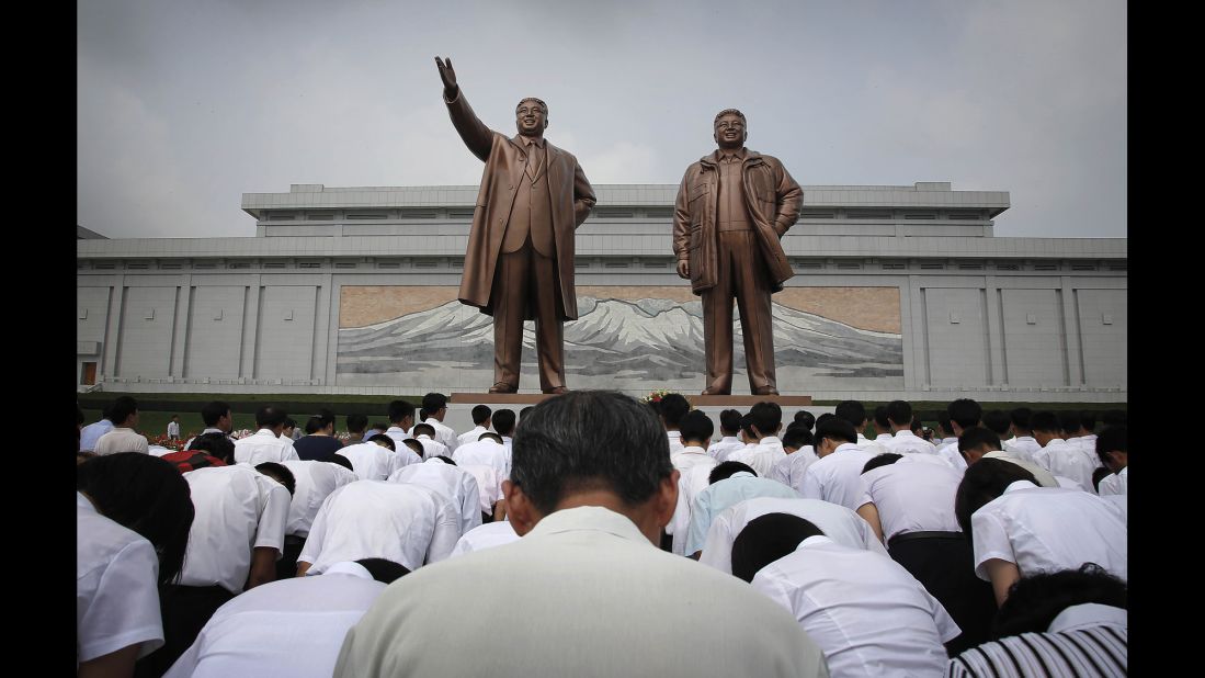 North Koreans bow in front of statues depicting the late leaders Kim Il Sung and Kim Jong Il at Munsu Hill during celebrations for the 62nd anniversary of the Korean War armistice.