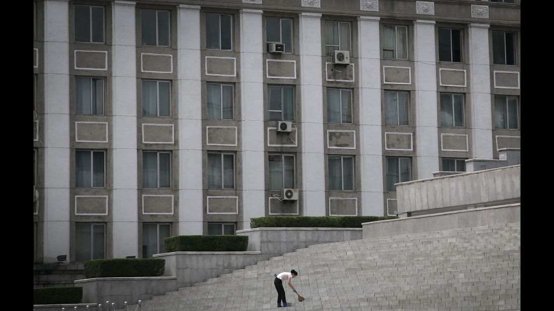 A woman sweeps stairs at Kim Il Sung Square. "When I am looking for street features and have opportunities to shoot North Koreans doing what they do, sometimes they don't understand why I am taking their photo," Wong said. "They don't see what is so interesting about what they are doing."
