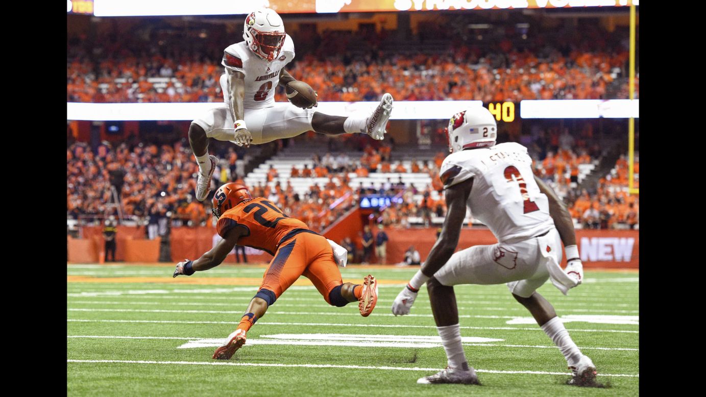 Louisville quarterback Lamar Jackson leaps over Syracuse's Cordell Hudson during the second quarter in Syracuse, New York, on Friday, September 9. Louisville won 62-28.