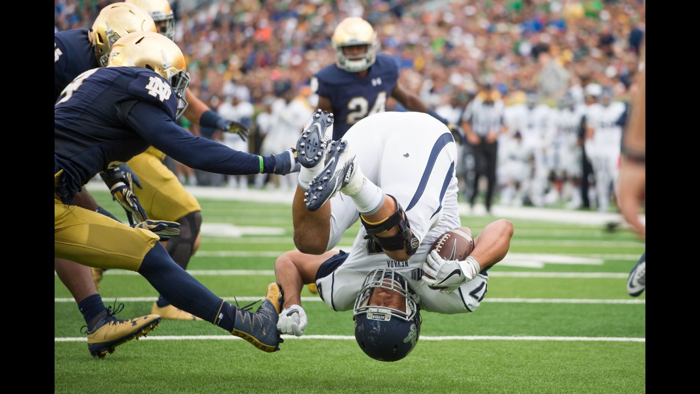 Nevada's Jarred Gipson flips as he is tackled by Notre Dame's Te'von Coney during a college game in South Bend, Indiana, on Saturday, September 10. Notre Dame won 39-10.