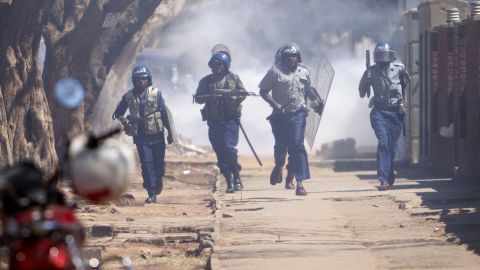 Zimbabwean anti-riot police chase opposition activists in August in Harare. 