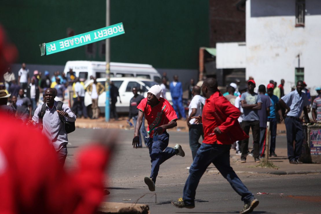 A protester throws a street sign with  Mugabe's name on it during clashes in August. 