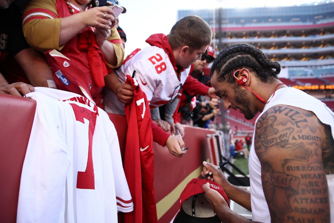 Kaepernick signs an autograph for a fan prior to playing the Los Angeles Rams in their NFL game at Levi's Stadium.