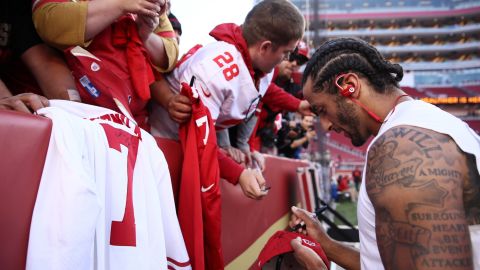 Kaepernick signs an autograph for a fan prior to playing the Los Angeles Rams in their NFL game at Levi's Stadium.