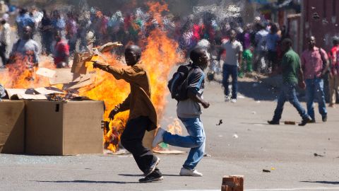 Protesters set up a burning barricade as they clash with police in Harare in August.