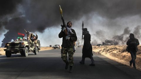Libyan rebels battle government troops as smoke from a damaged oil facility darkens the skyline on March 11, 2011, in Ras Lanuf, Libya.