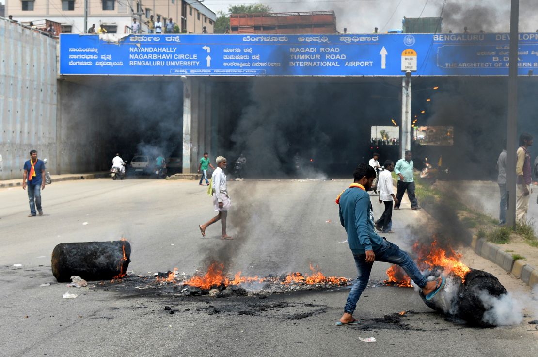 An Indian activist removes a traffic blockade on a major connecting road during a statewide strike in Bangalore on September 9, 2016.