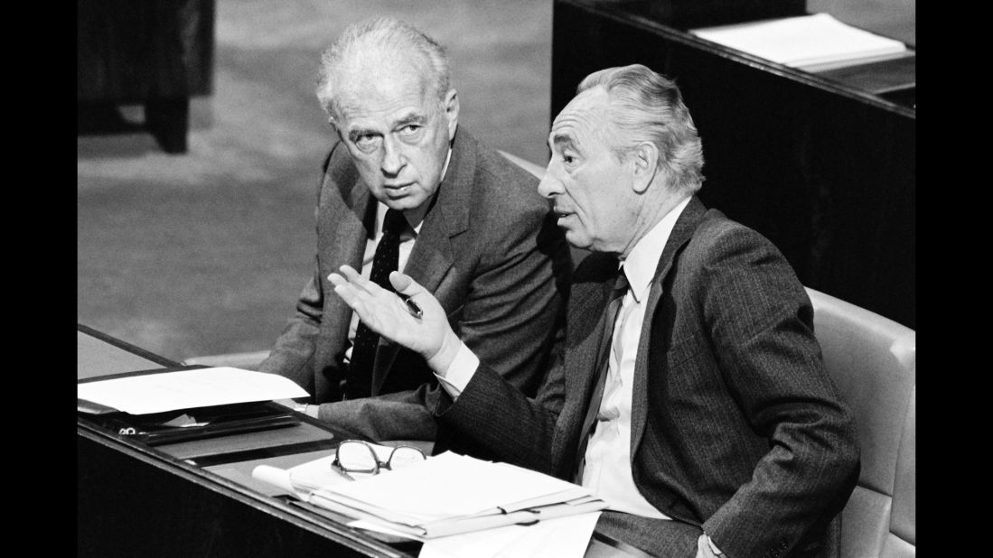 Israeli Foreign Minister Shimon Peres, right, consults with Defense Minister Yitzhak Rabin on November 26, 1986, during a vote in the Israeli parliament, Knesset, about shipments of arms to Iran.  