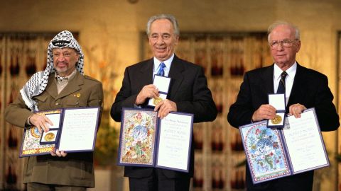 Palestinian leader Yasser Arafat, left, Israeli Foreign Minister Shimon Peres  and Israeli Premier Yitzhak Rabin display their Nobel Peace Prizes on December 10, 1994 in Oslo, Norway. 