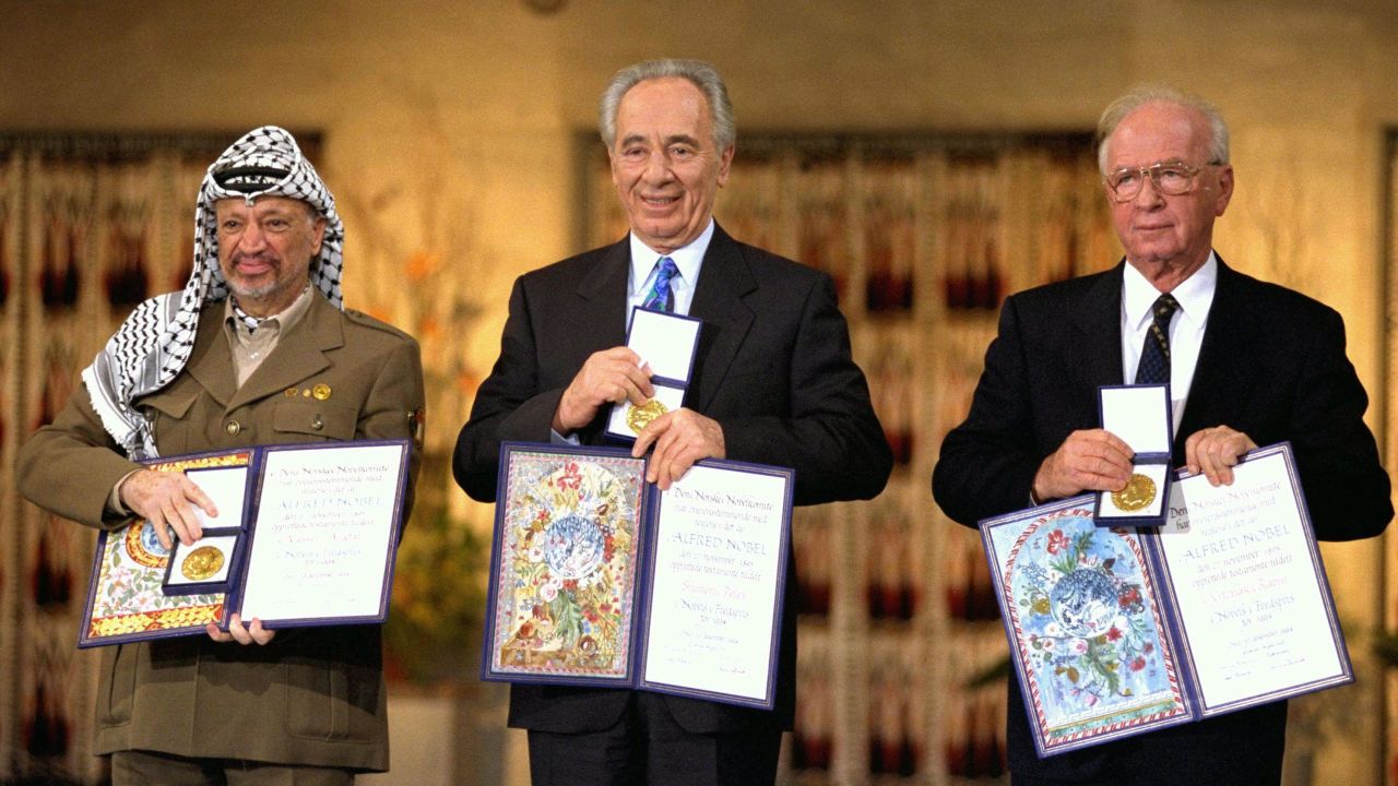 Palestinian leader Yasser Arafat (L), Israeli Foreign Minister Shimon Peres (C) and Israeli Premier Yitzhak Rabin display their Nobel Peace Prizes.