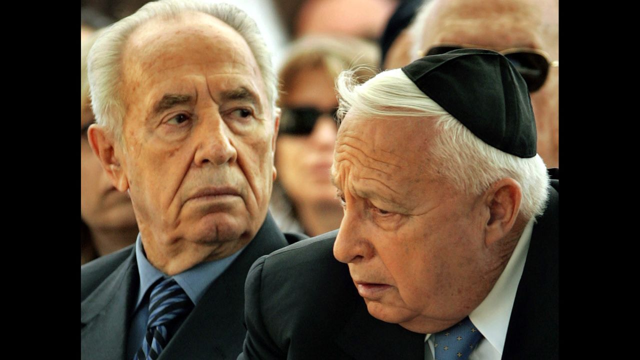 Israeli Vice-Premier Shimon Peres, left, and Israeli Prime Minister Ariel Sharon attend the 32nd annual memorial ceremony for the late Israeli Prime Minister David Ben-Gurion in the southern Israeli kibbutz of Sde Boker on December 7, 2005. 