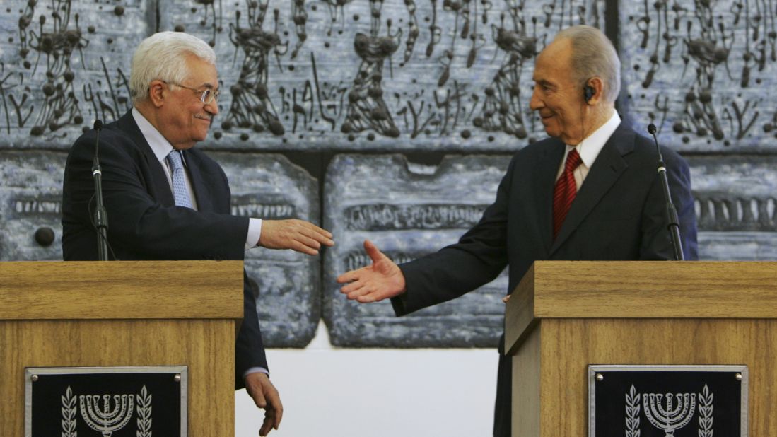 Palestinian President Mahmoud Abbas reaches to shake hands with Israeli President Shimon Peres prior to their meeting in Jerusalem on July 22, 2008. Abbas had threatened to withdraw his forces from West Bank cities unless Israel's military halted its raids into the areas.