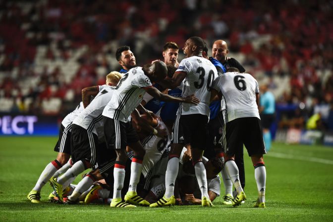 Talisca is buried by his Besiktas teammates after scoring a dramatic long-range free-kick -- converted in the 93rd minute -- to earn a 1-1 draw against parent club Benfica. 