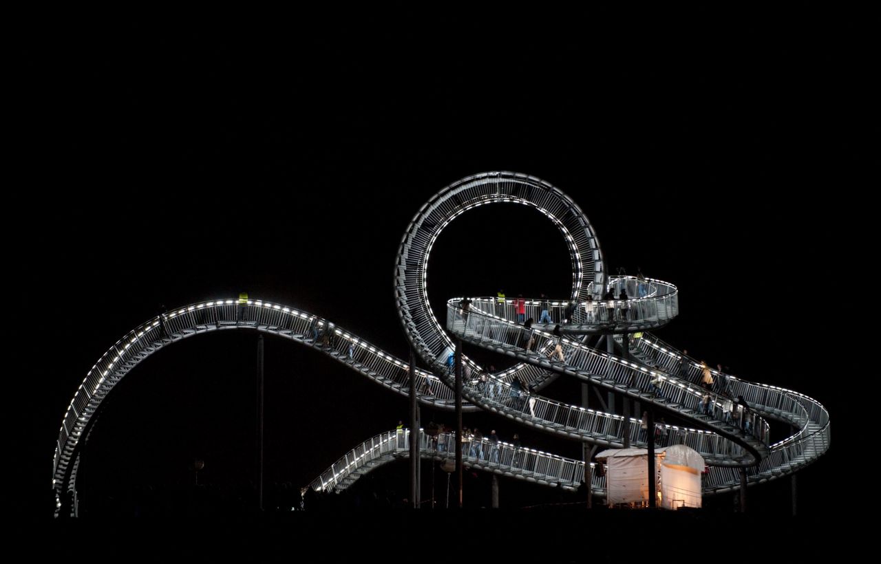 Visitors walk on the just inaugurated sculpture "Tiger & Turtle - Magic Mountain" by German artists Heike Mutter and Ulrich Genth.